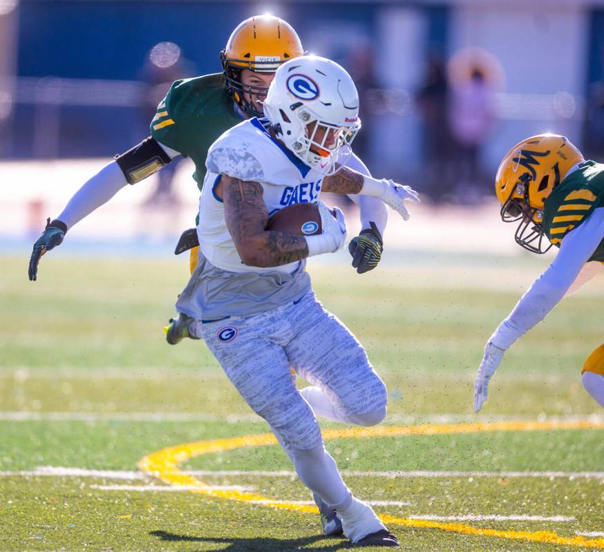 Bishop Gorman WR Trech Kekahuna (23) fights off a tackle by Bishop Manogue DB Carson Jensen (99 ...
