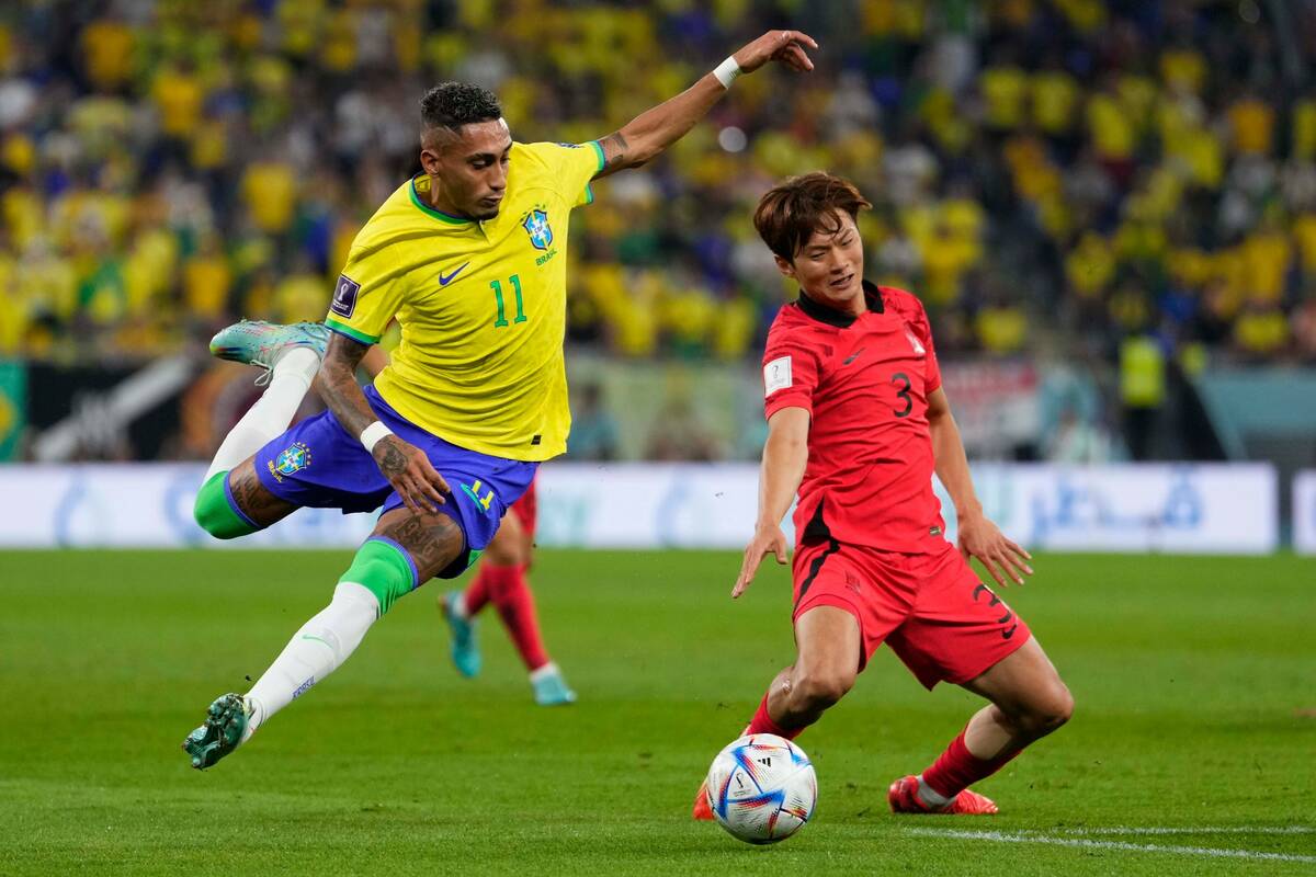 Brazil's Raphinha , left, and South Korea's Kim Jin-su challenge for the ball during the World ...