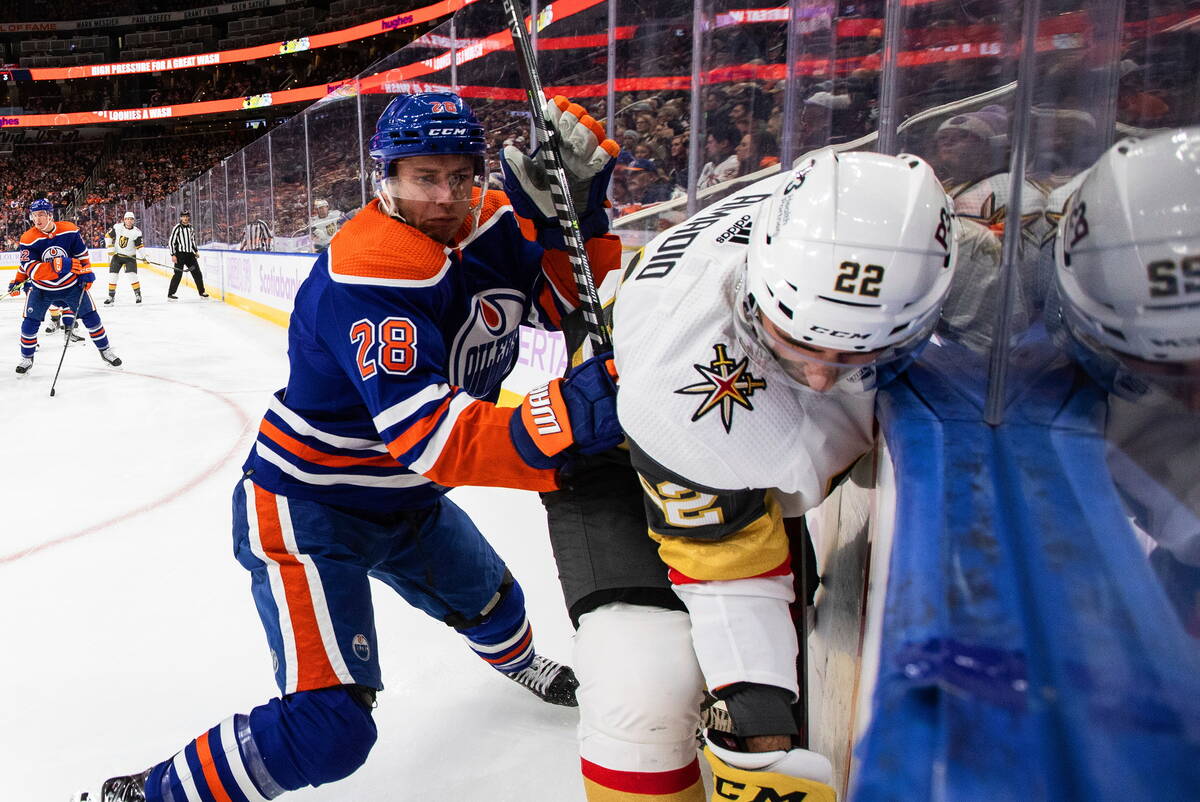 Vegas Golden Knights' Michael Amadio (22) is checked by Edmonton Oilers' Ryan Murray (28) durin ...