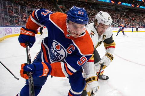 Vegas Golden Knights' Mark Stone (61) and Edmonton Oilers' Connor McDavid (97) vie for the puck ...