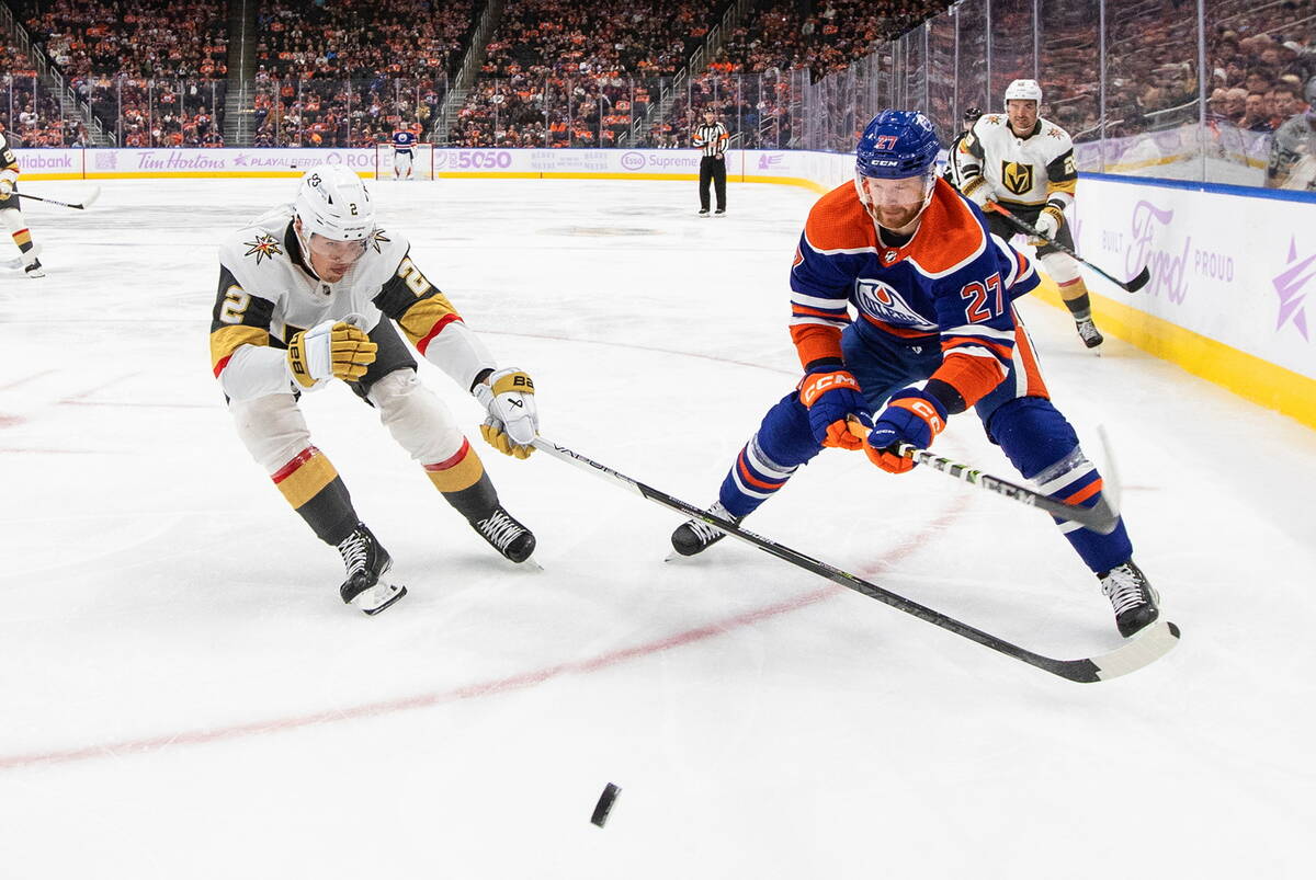 Vegas Golden Knights' Zach Whitecloud (2) and Edmonton Oilers' Brett Kulak (27) vie for the puc ...