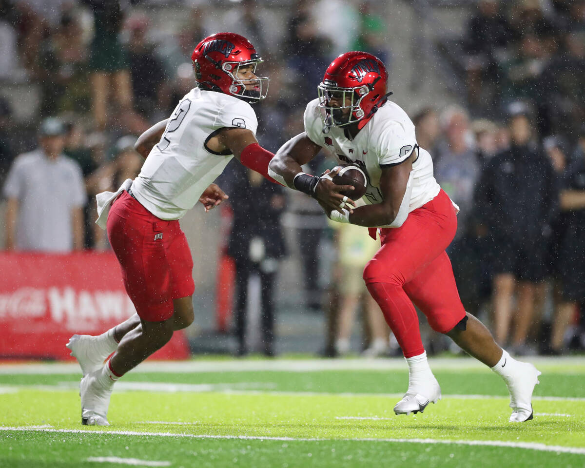 UNLV quarterback Doug Brumfield (2) hands the ball off running back Aidan Robbins (9) during th ...