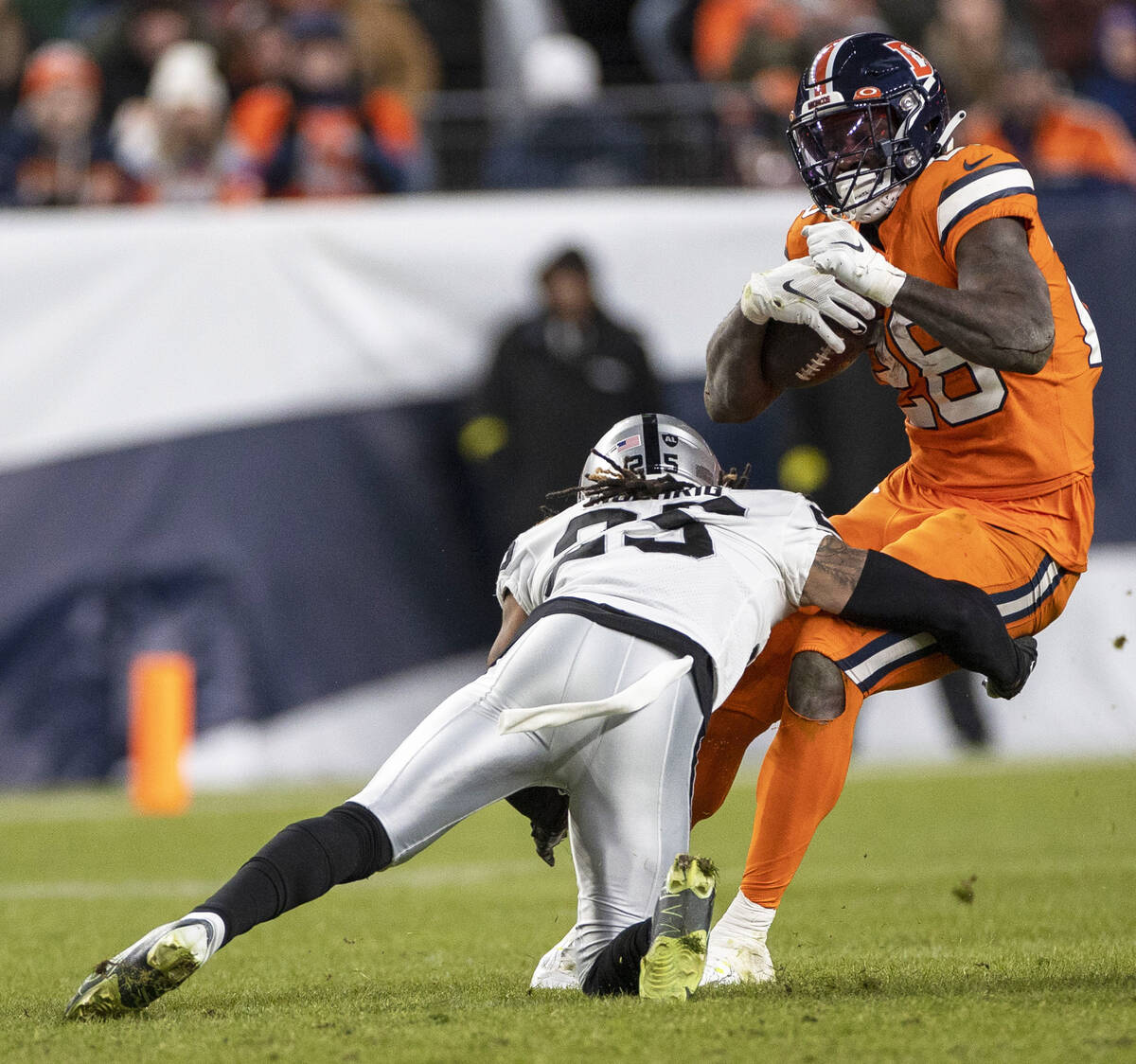 Raiders safety Tre'von Moehrig (25) tackles Denver Broncos running back Latavius Murray (28) d ...
