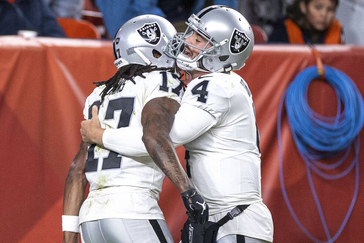 Raiders wide receiver Davante Adams (17) is congratulated by quarterback Derek Carr (4) after s ...