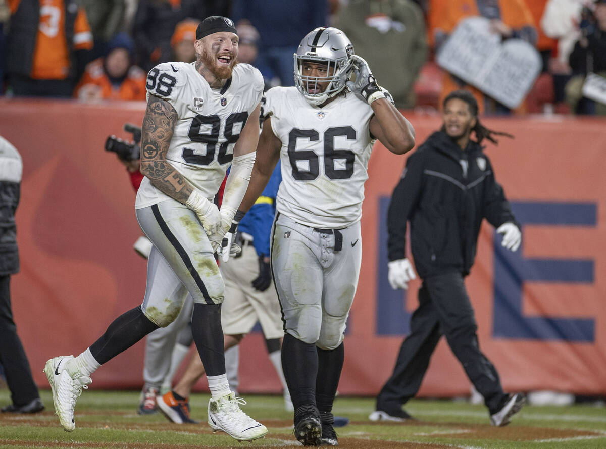 Raiders defensive end Maxx Crosby (98) runs on the field with offensive lineman Dylan Parham (6 ...