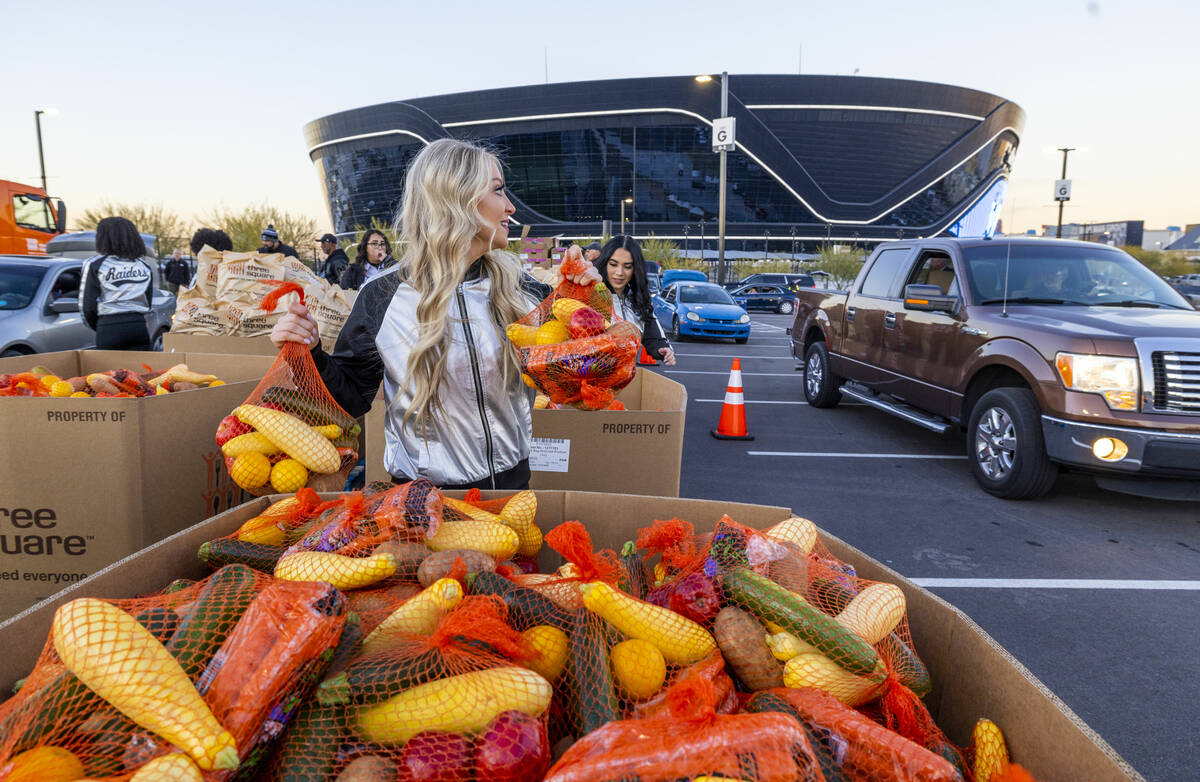 Raiderettes Melody and Kylie deliver bags of fruits and vegetables joining current and former R ...