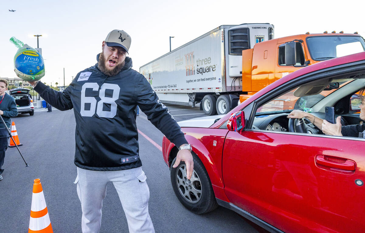 Raiders center Andre James (68) pretends to be spiking a turkey as he joins Raiders' current an ...