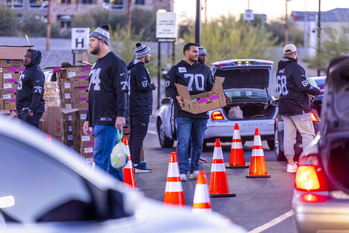 Raiders' current and former players along with staff members take part in a free Thanksgiving m ...