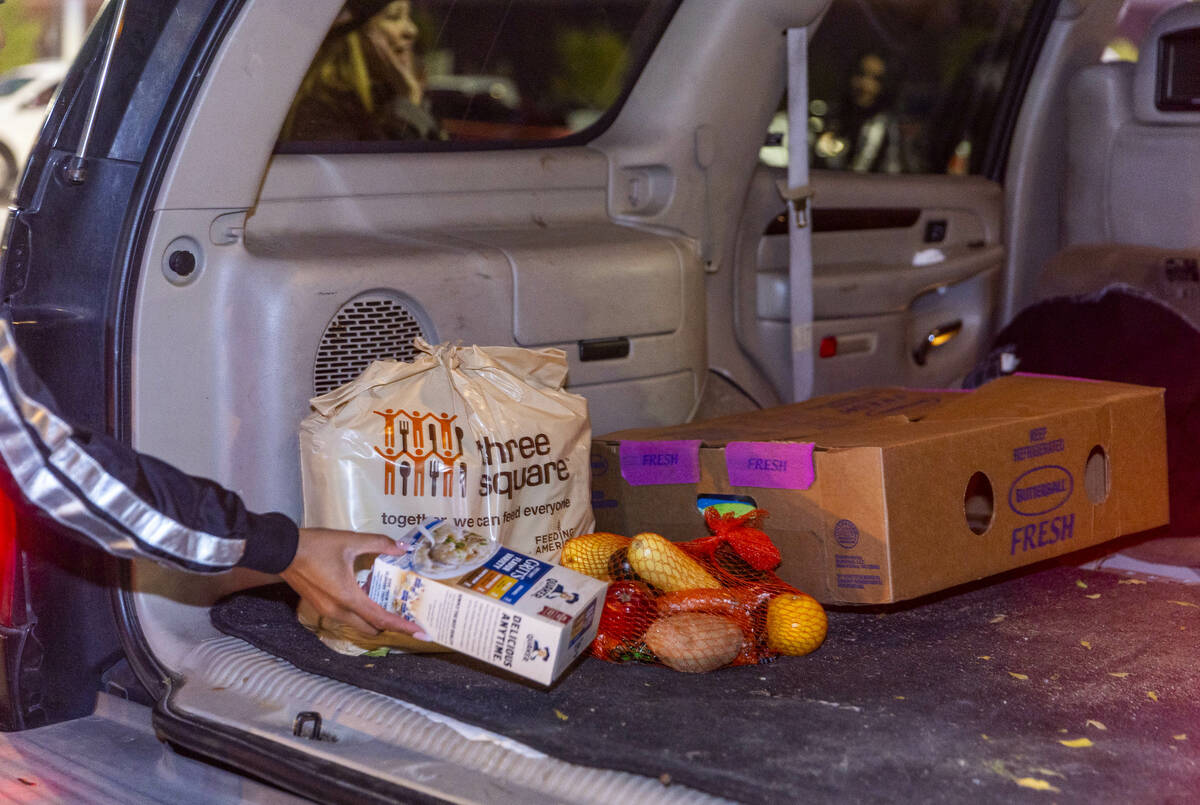 A complete meal is placed in a vehicle as Raiders' current and former players with staff take p ...
