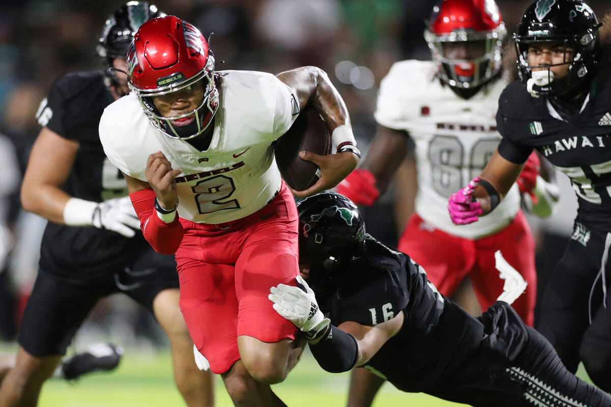 Hawaii linebacker Logan Taylor (16) tries to pull down UNLV quarterback Doug Brumfield (2) duri ...