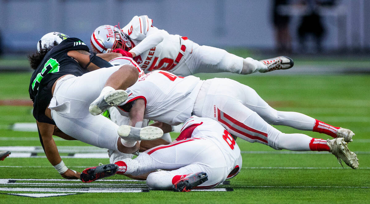 SLAM Academy TE Moses Tabangcura (33) is triple tackled by Truckee CB Jake Solberg (5), OLB Jak ...