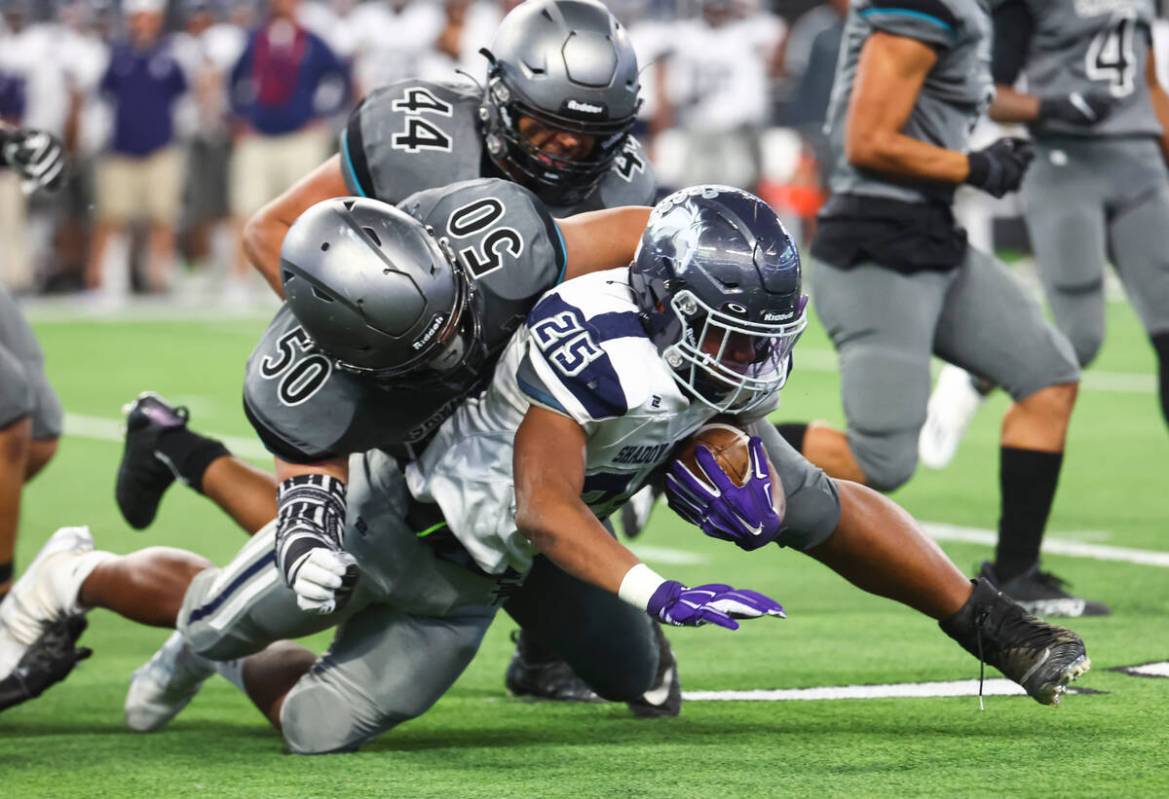 Shadow Ridge's JaQuieze Holland (25) gets tackled by Silverado's Aisaiah Feagai (50) during the ...