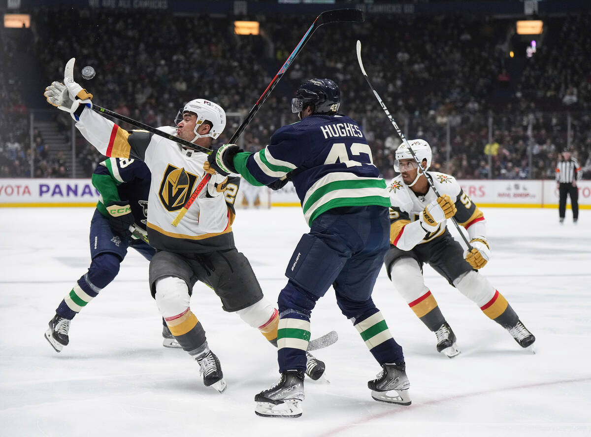 Vegas Golden Knights' William Carrier, front left, and Vancouver Canucks' Quinn Hughes (43) vie ...