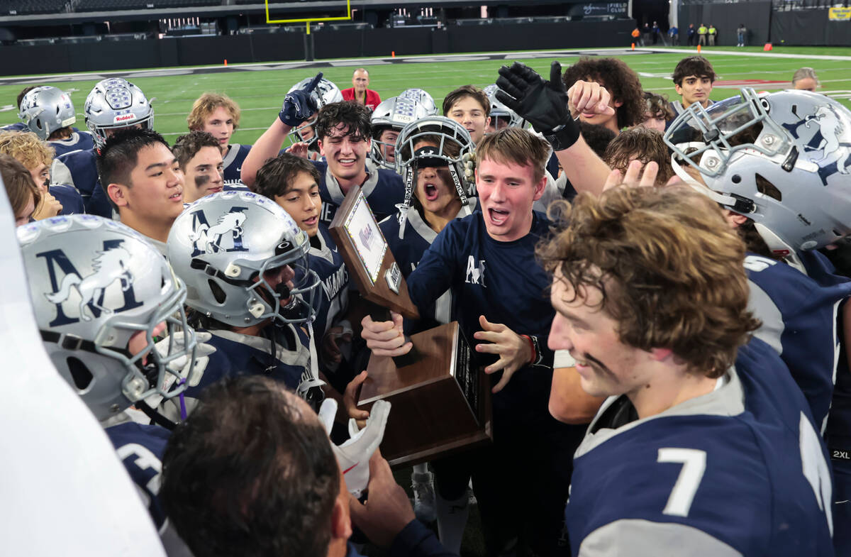 The Meadows players celebrate with the trophy after defeating Lincoln County to win the Class 2 ...