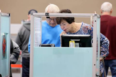 Voter Doris Burnett of Las Vegas casts her ballot with the help of her life partner Marshall Bi ...