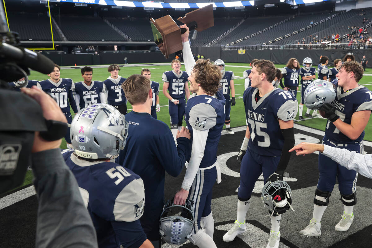 The Meadows' Sean Gosse (7) raises the trophy to celebrate after defeating Lincoln County to wi ...