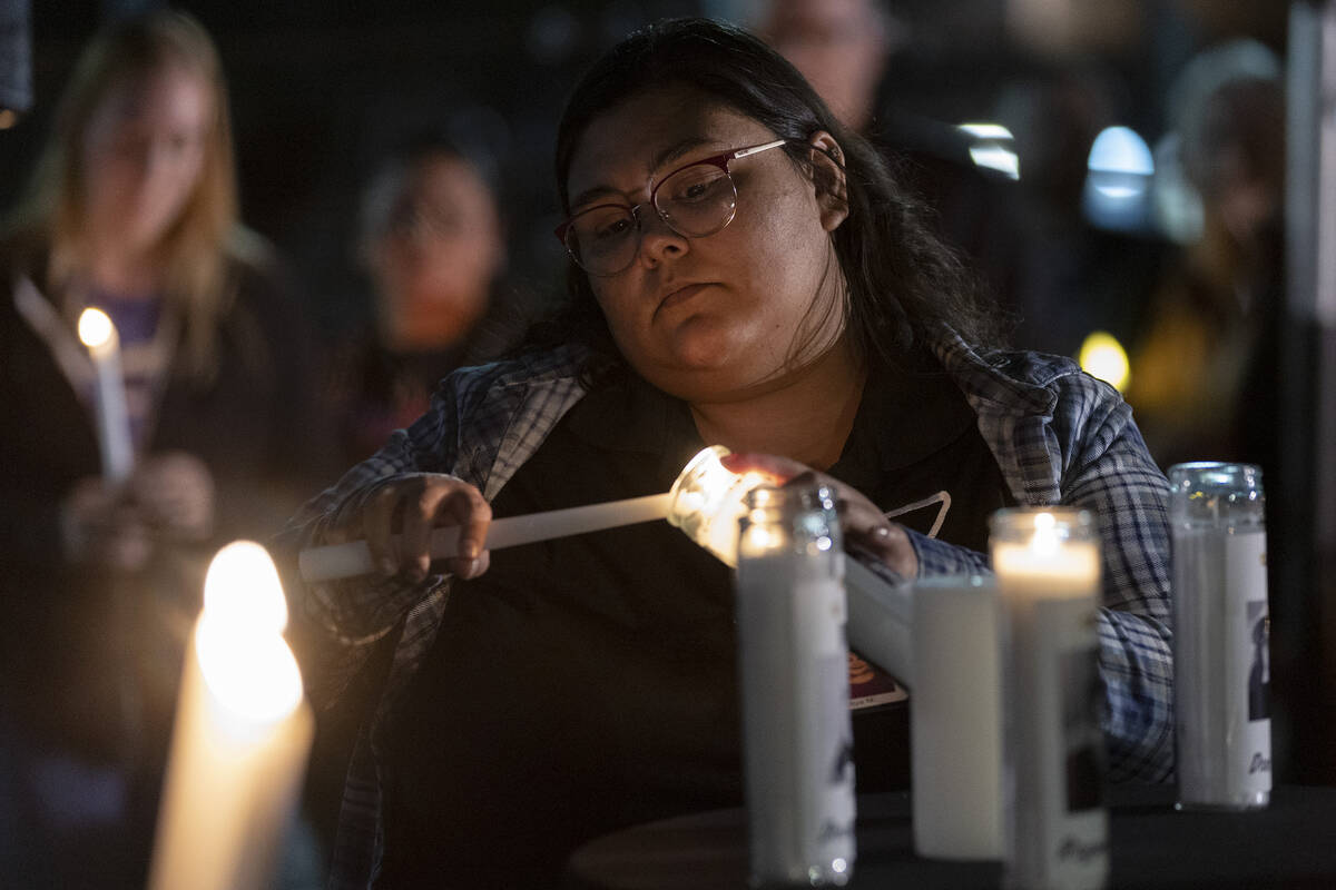 Miya Morales, an HIV advocate at The Center, lights candles in honor of the Club Q victims duri ...