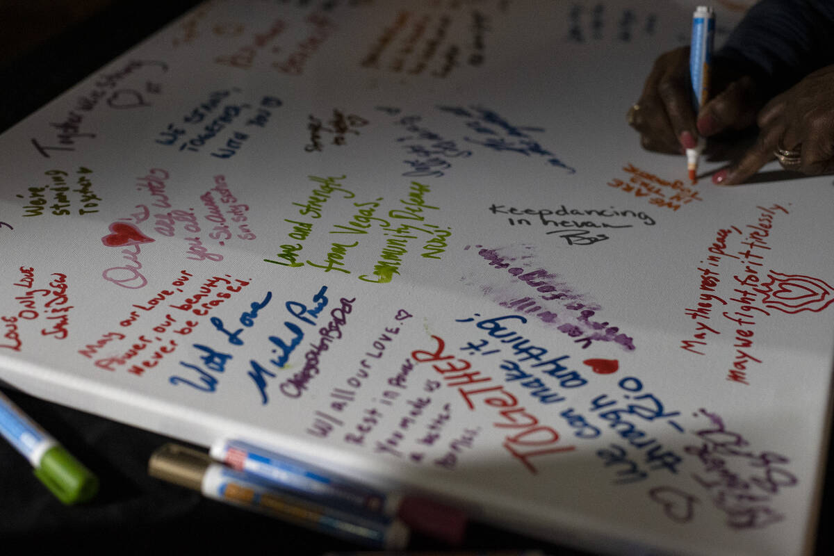 Mourners write notes on a canvas during a vigil at the LGBTQ Center of Southern Nevada on Tuesd ...