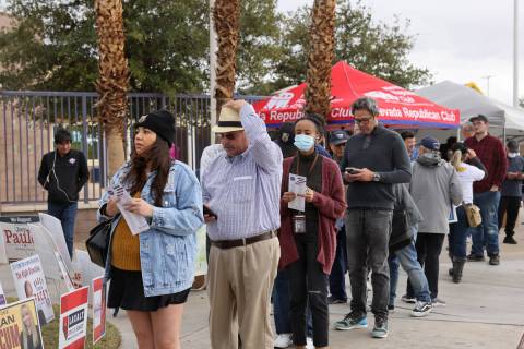 Voters brave high winds and rain drops while waiting in line on Election Day at Desert Breeze C ...