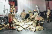 Firefighters work at the scene of a crash in the southbound lanes of -15 north of downtown Las ...
