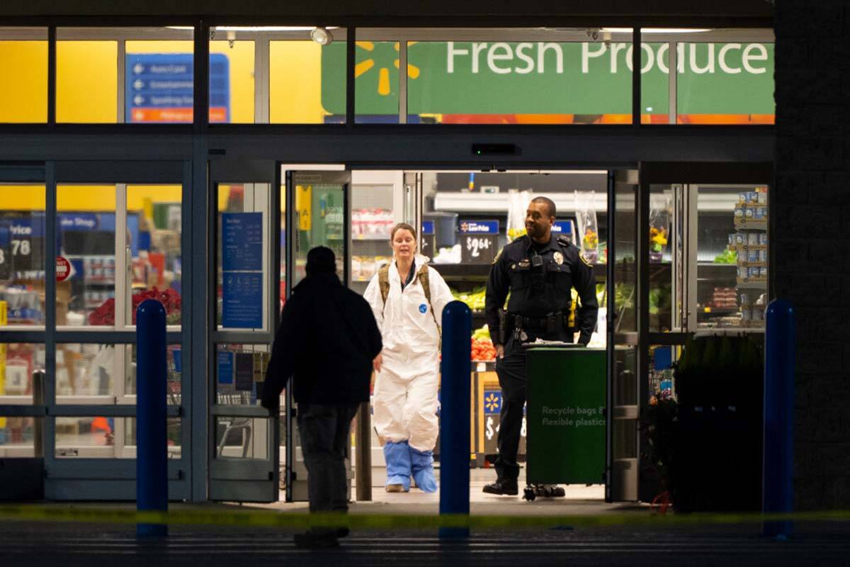 A law enforcement investigator wears a protective covering as they work the scene of a mass sho ...