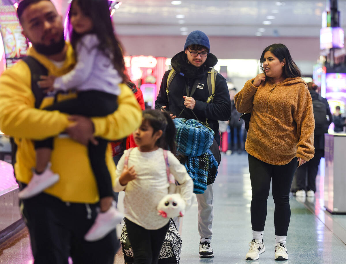 Travelers walk through the baggage claim at Harry Reid International Airport in Las Vegas, Wedn ...