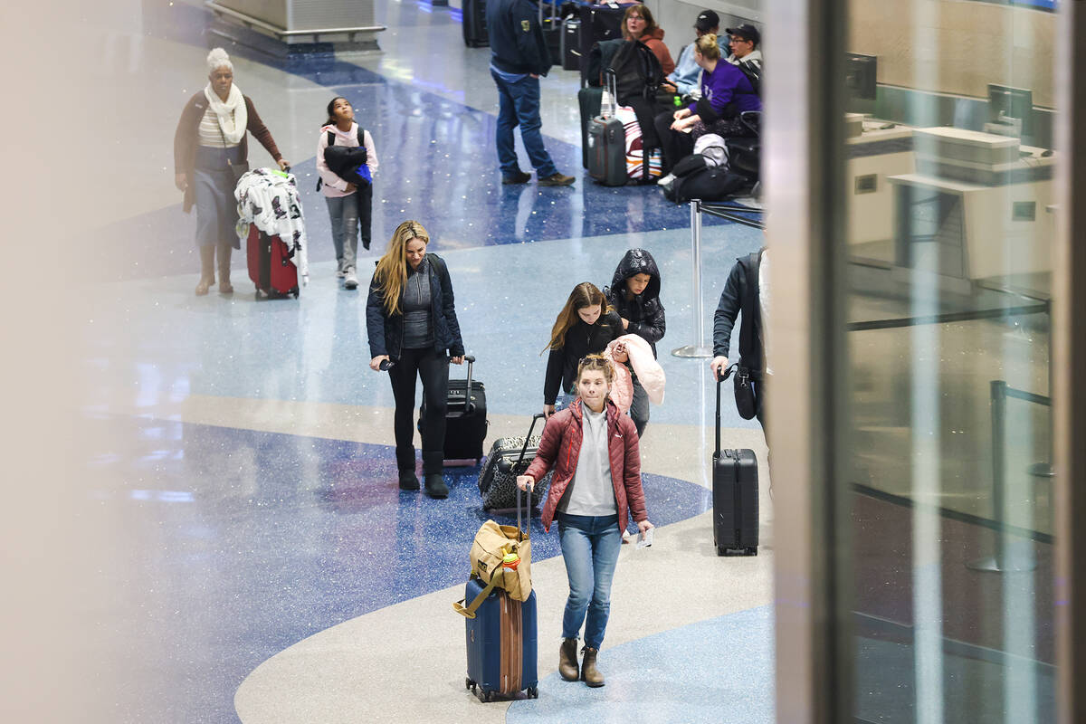 Travelers walk through Harry Reid International Airport in Las Vegas, Wednesday, Nov. 23, 2022. ...