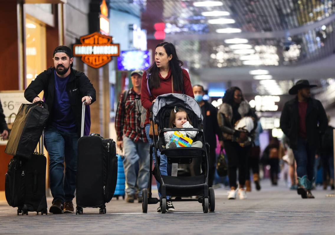 Travelers walk through Harry Reid International Airport in Las Vegas, Wednesday, Nov. 23, 2022. ...