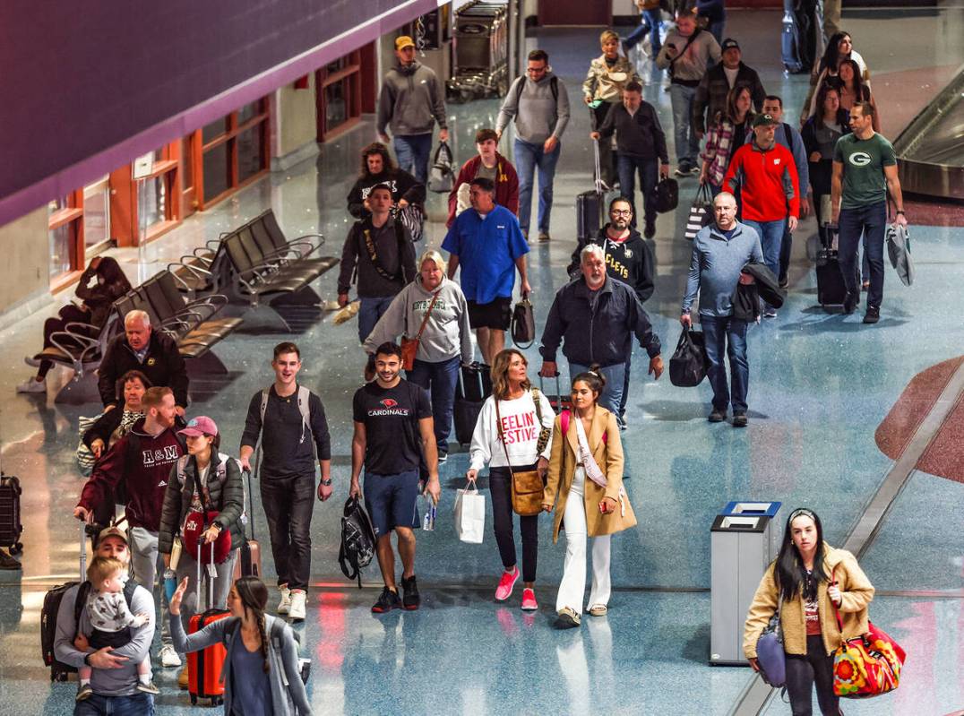 Travelers walk through the baggage claim at Harry Reid International Airport in Las Vegas, Wedn ...