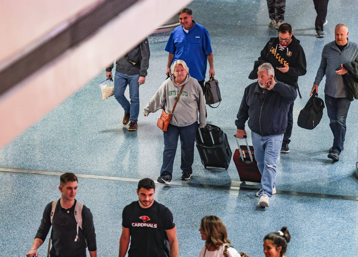 Travelers walk through the baggage claim at Harry Reid International Airport in Las Vegas, Wedn ...