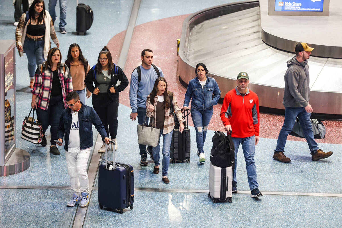 Travelers walk through the baggage claim at Harry Reid International Airport in Las Vegas, Wedn ...