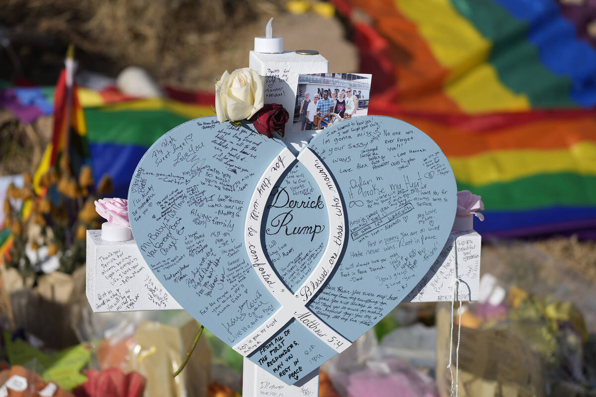 Hand-written messages cover the heart attached to the cross to honor a victim of the mass shoot ...