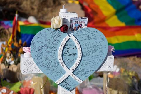 Hand-written messages cover the heart attached to the cross to honor a victim of the mass shoot ...