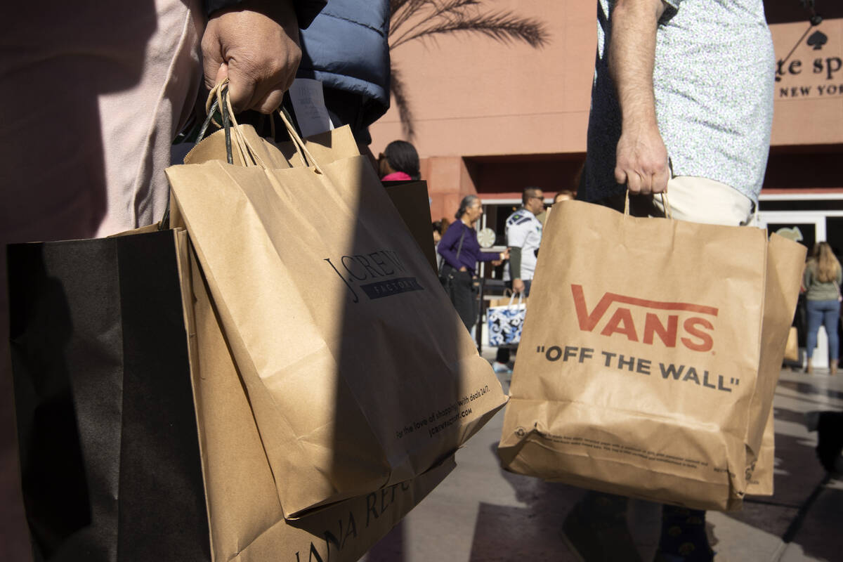 Shoppers carry their purchases during Black Friday sales at Las Vegas North Premium Outlets on ...