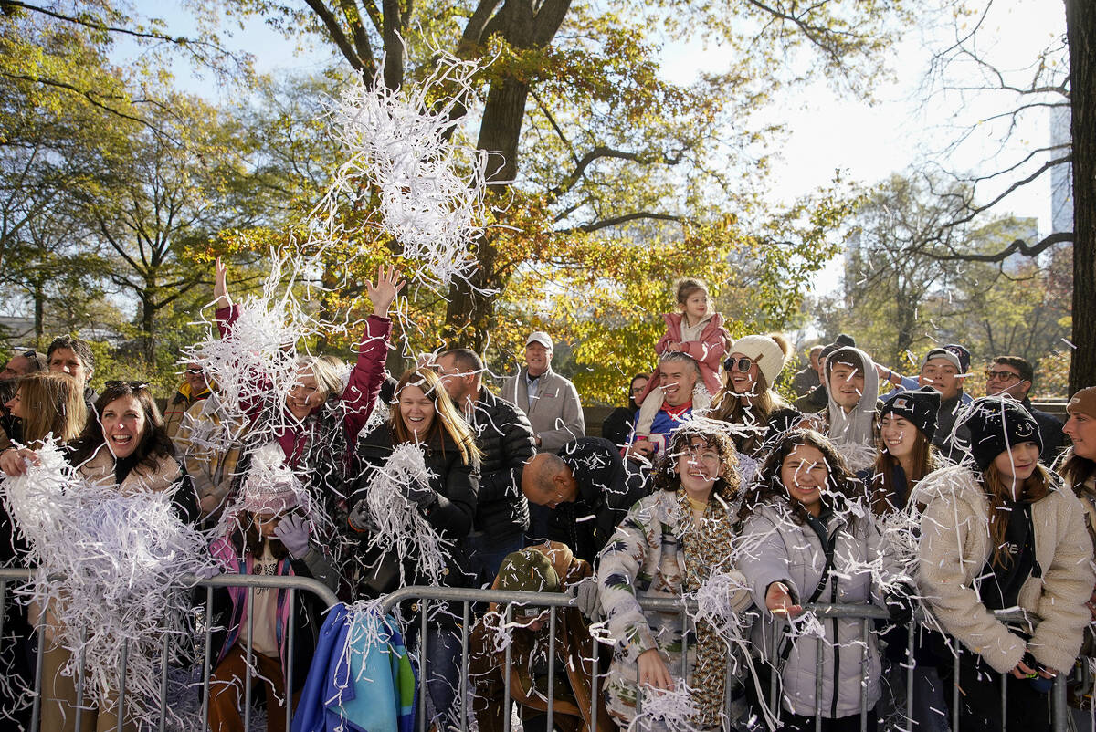 Spectators toss confetti as the parade makes its way down Central Park Avenue West during the M ...