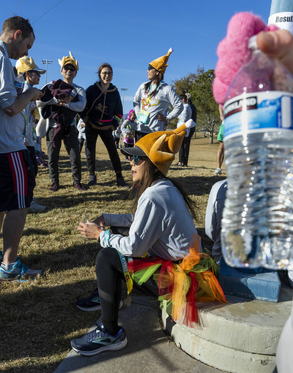 Participants in Thanksgiving costumes have fun while watching at the finish line on the course ...