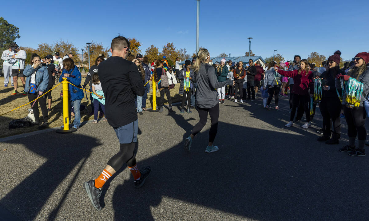 Participants are cheered at the finish line on the course during the Wobble Before You Gobble 5 ...
