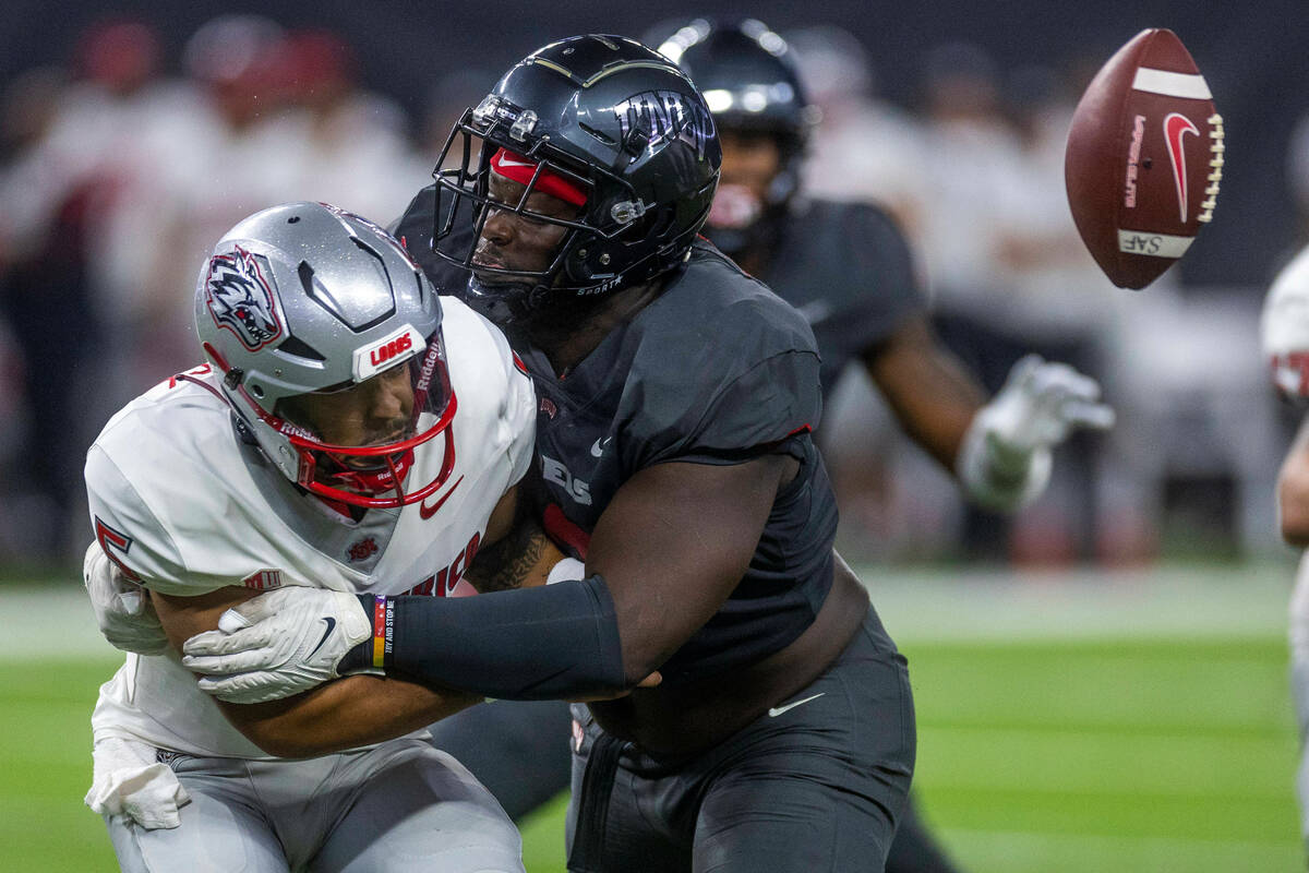 New Mexico Lobos quarterback Miles Kendrick (5) lets the ball go as UNLV Rebels defensive linem ...