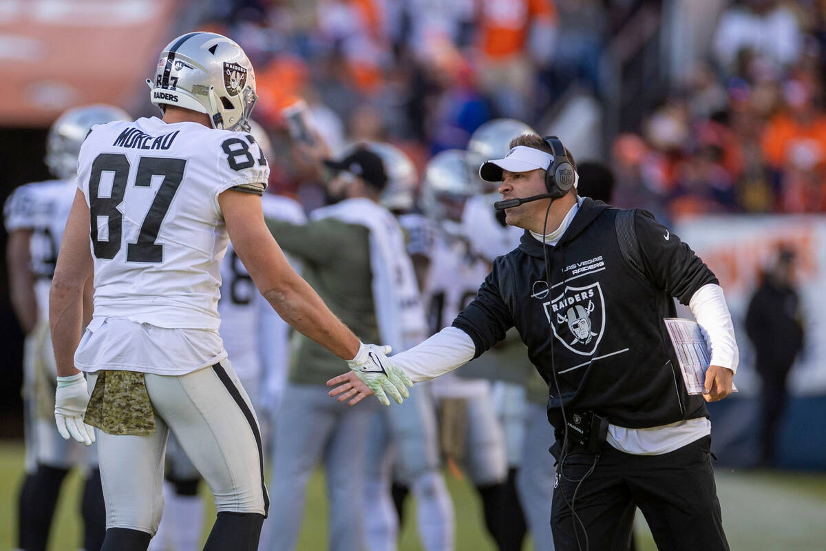 Raiders head coach Josh McDaniels congratulates Raiders tight end Foster Moreau (87) after a sp ...