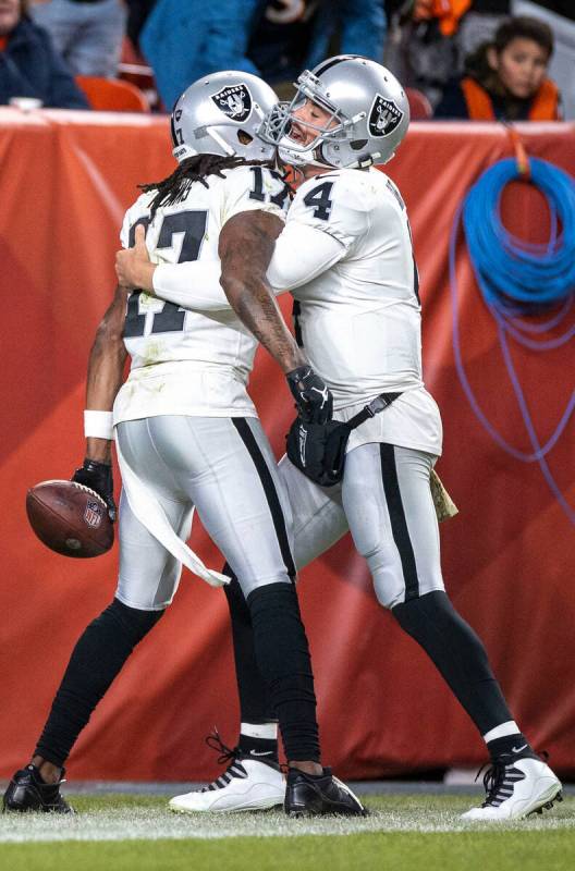 Raiders wide receiver Davante Adams (17) is congratulated by quarterback Derek Carr (4) after s ...