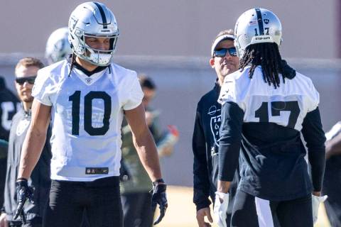 Raiders head coach Josh McDaniels, center, meets with wide receivers Mack Hollins (10) and Dava ...