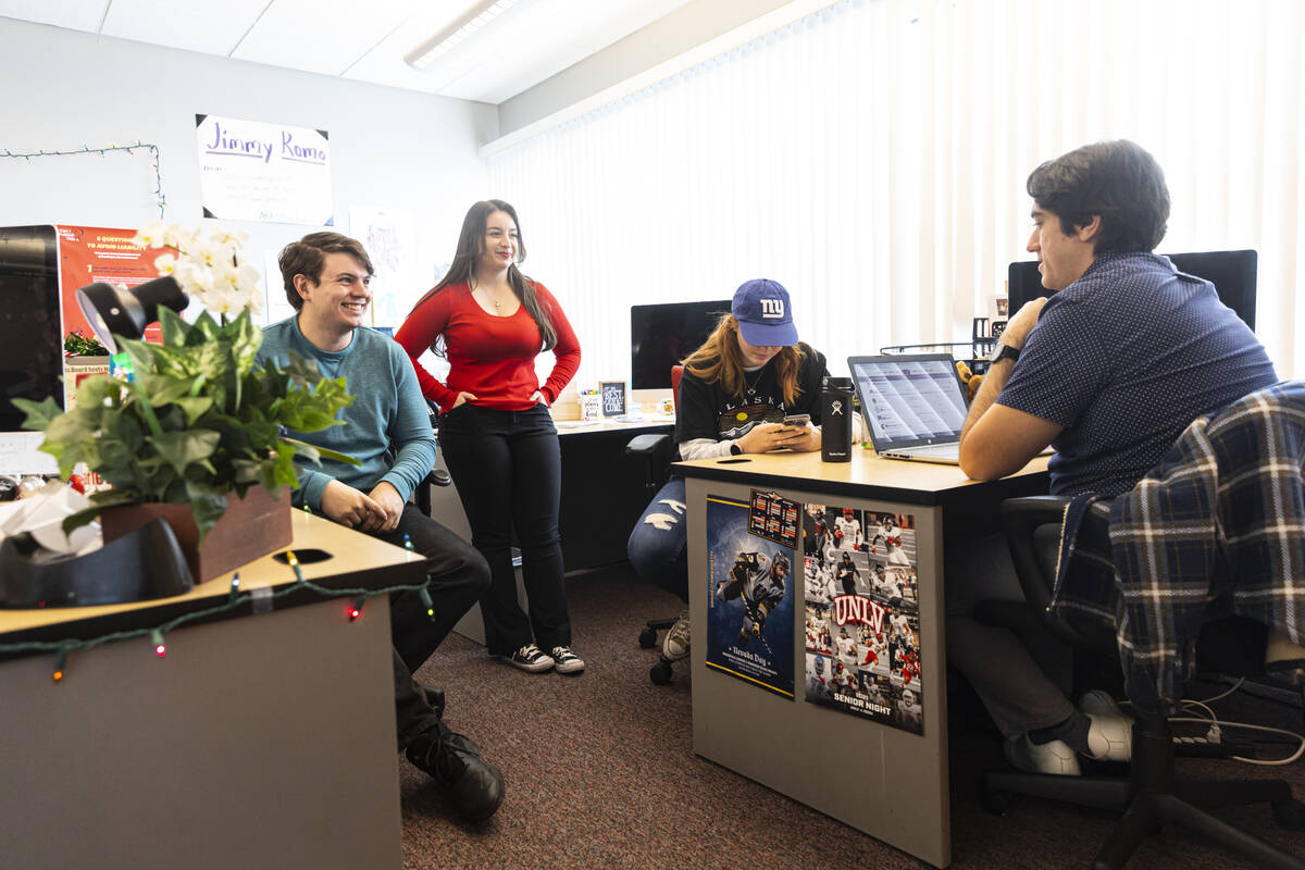 Mark Credico, copy chief at the The Scarlet & Gray Free Press, left, talks with, from left, Van ...