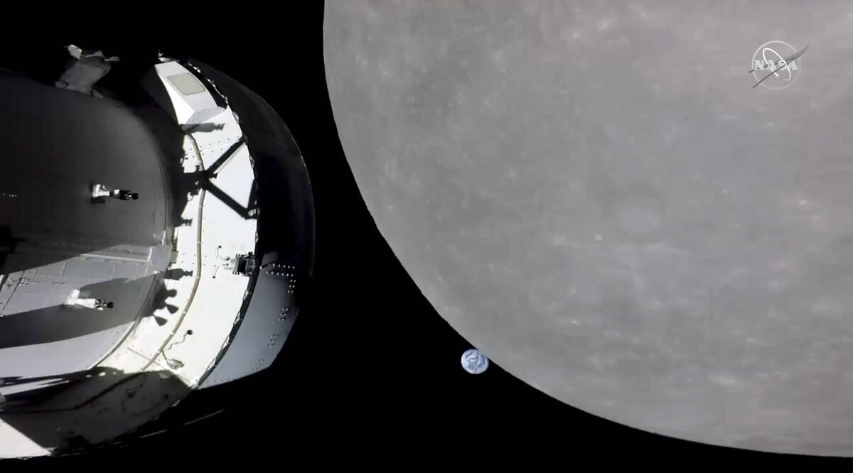 This screengrab from NASA TV shows NASA's Orion capsule, left, nearing the moon, right, Monday, ...