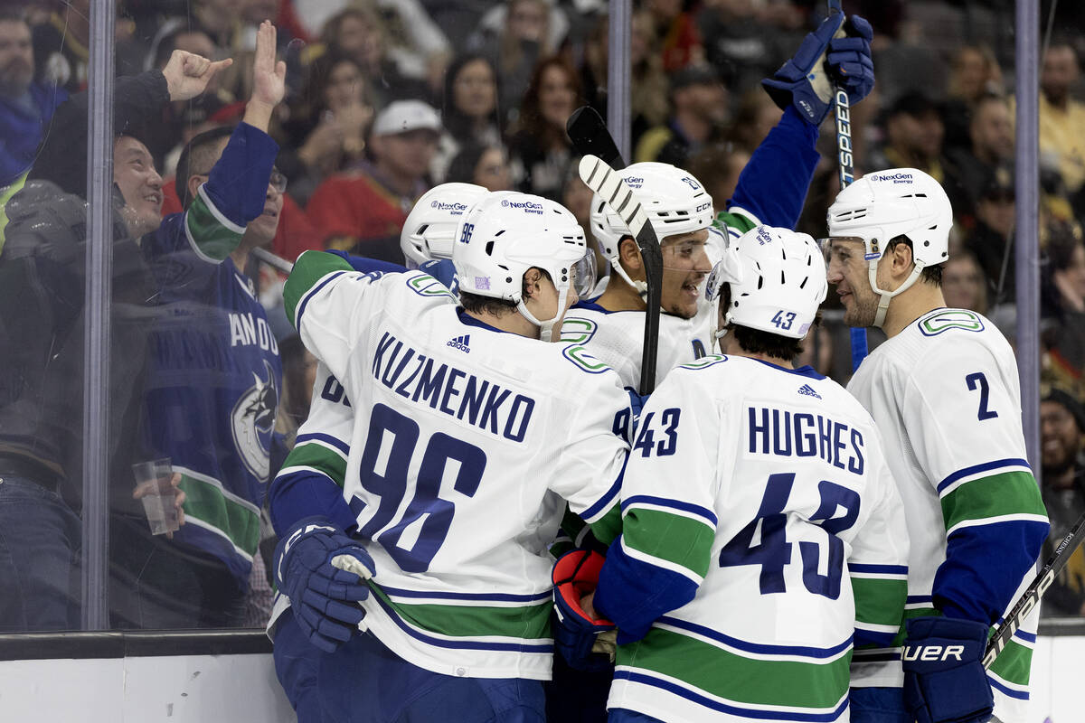 The Canucks celebrate after scoring a goal during the second period of an NHL hockey game again ...
