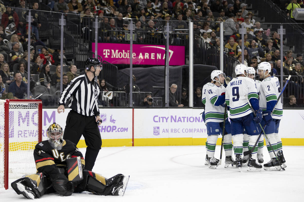 The Canucks celebrate their fifth goal of the night while Golden Knights goaltender Logan Thomp ...