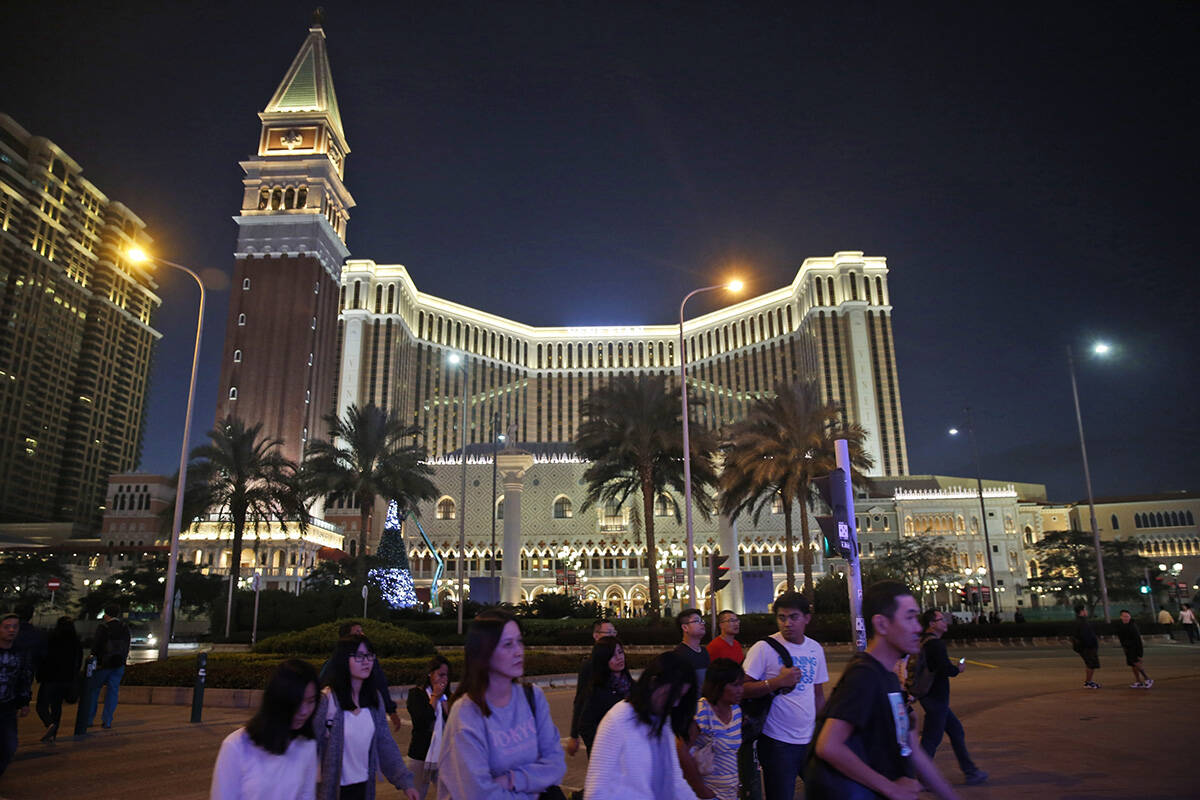 FILE - In this Nov. 23, 2014, file photo, people walk across a road in front of the Venetian Ma ...
