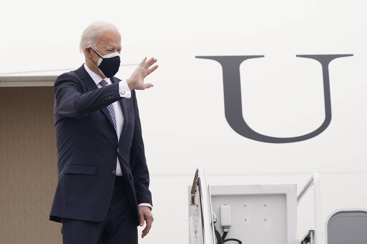 President Joe Biden waves from the top of the steps of Air Force One at Andrews Air Force Base, ...
