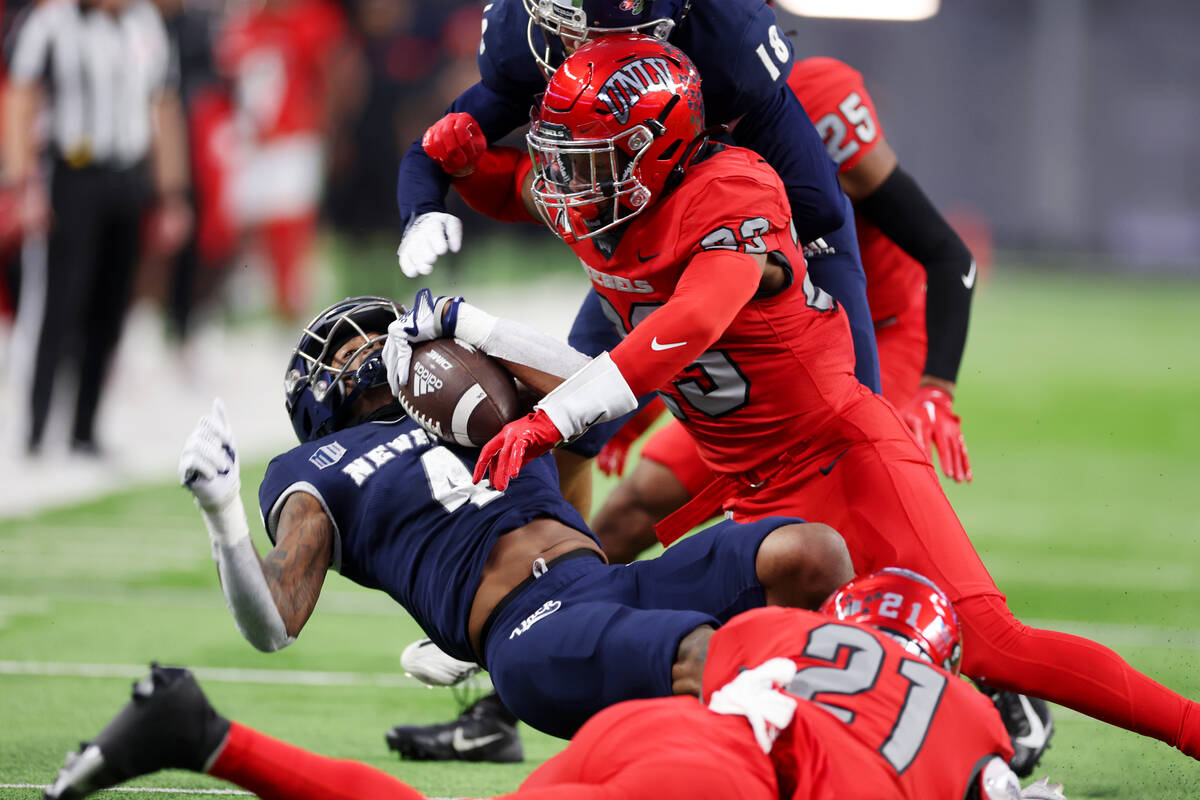 UNLV Rebels defensive back Jerrae Williams (23) tackles Nevada Wolf Pack wide receiver BJ Caste ...