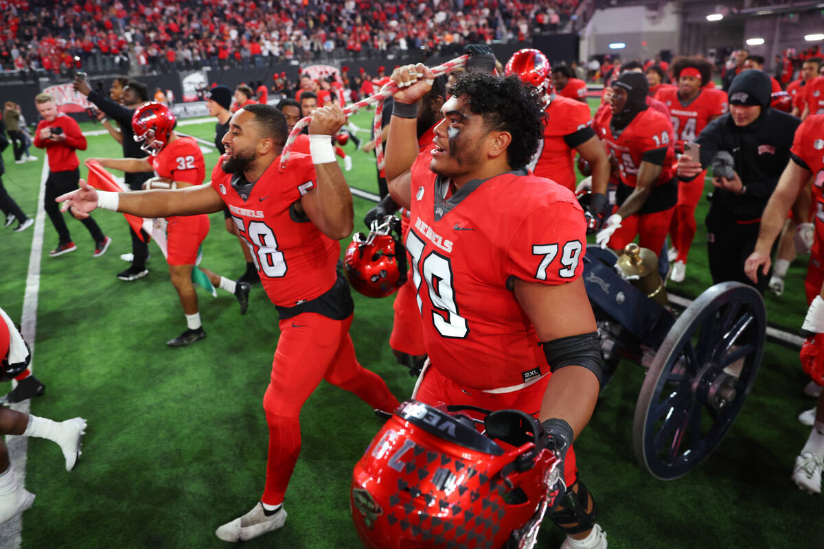 UNLV Rebels linebacker Seth Robinson (58) and offensive lineman Leif Fautanu (79) pull the Frem ...