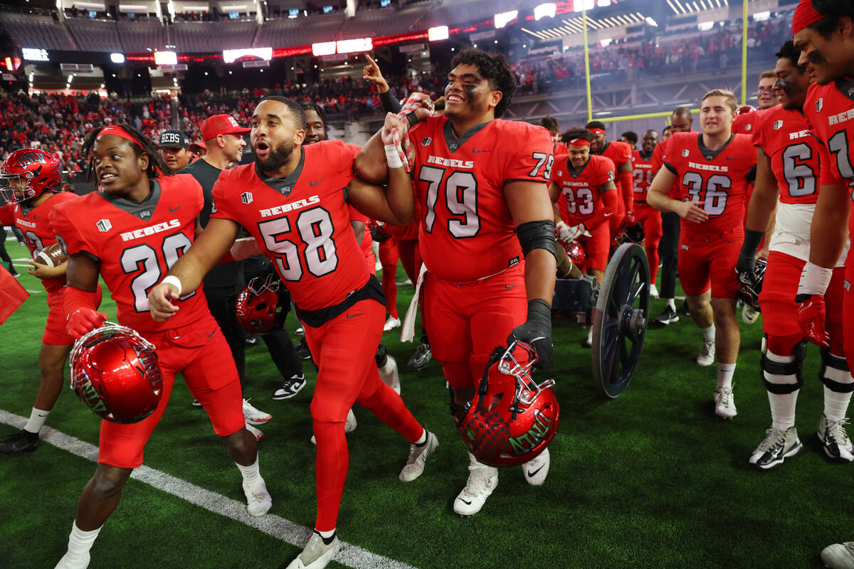 UNLV Rebels linebacker Seth Robinson (58) and offensive lineman Leif Fautanu (79) pull the Frem ...